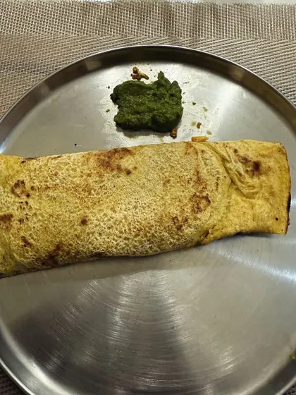 A besan cheela (gram flour pancake) served with green chutney. This is a high-protein, gluten-free option that is great for weight loss.