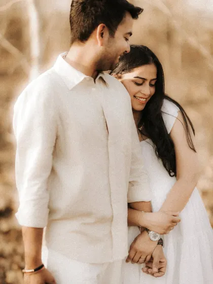 A close-up shot filled with warmth and genuine smiles. This candid portrait captures the couple's comfortable embrace and the joy they find in each other's company.
