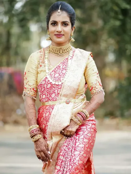 A stunning client in a cream and red brocade saree. The makeup is kept classic and elegant to complement the rich fabric and gold jewellery.