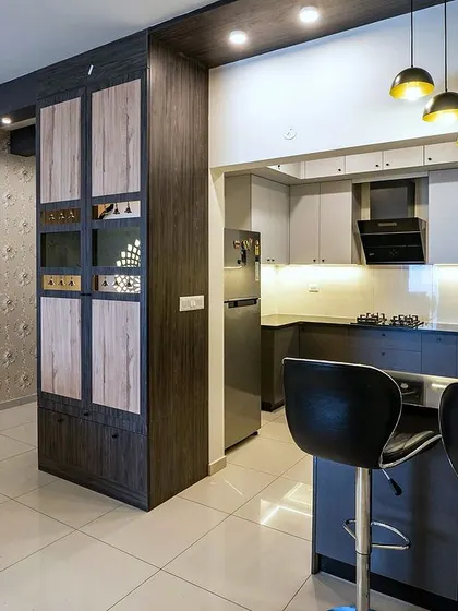 The 'Blackwood' apartment kitchen features a compact and efficient layout with a dark wood and grey color scheme, a breakfast counter, and stylish pendant lighting.