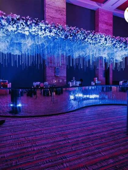 The bar for the celestial-themed party was a showstopper. A canopy of flowers and hanging crystals glowed under the moody lighting, complementing the starry night theme.