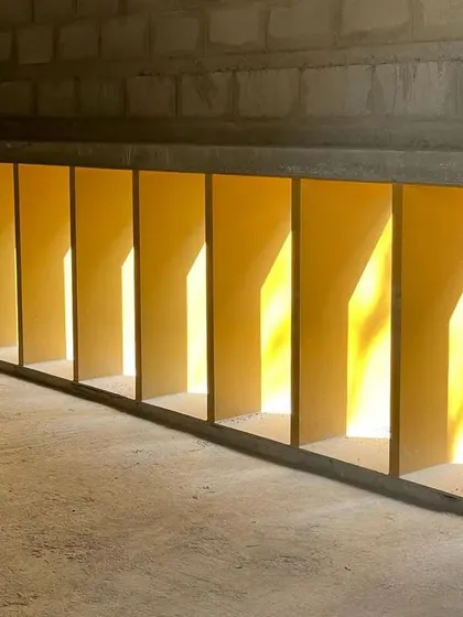 A detail of the gallery's lower window openings during construction. The play of light and shadow through these repeating forms is an intentional design element, visible even at this early stage.