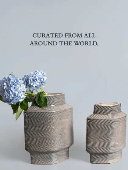 Curated from all around the world, these grey ceramic vases feature a subtle chevron pattern. Their geometric form and neutral tone make them incredibly versatile for any modern living space.