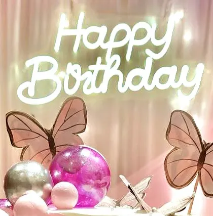 A close-up of a 'Happy Birthday' neon sign, a popular addition for creating a modern and celebratory vibe. This was part of a pink and purple themed birthday.