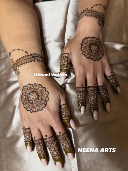 A chic and minimal design featuring a lotus mandala on the back of the hand with a delicate chain-like pattern on the wrist.