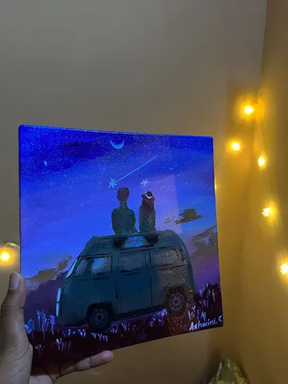 Holding up my starry night van painting, with fairy lights creating a magical glow.