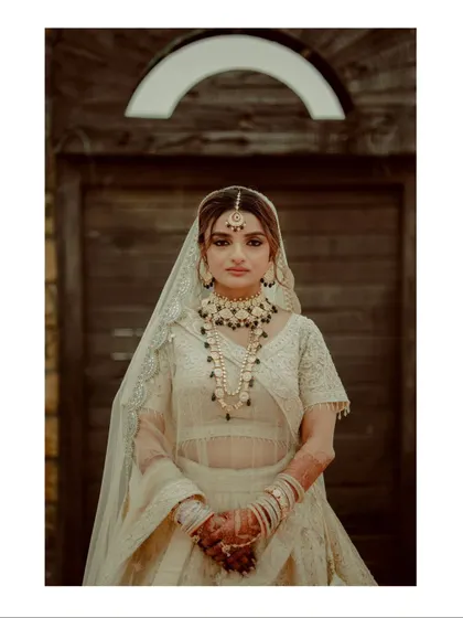 A classic bridal portrait in a beautiful white lehenga, with a simple yet elegant composition that highlights her grace.