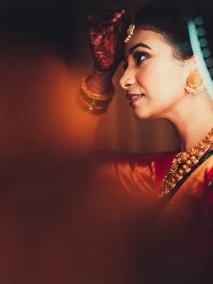 An artistic shot of the bride getting ready, with a creative use of foreground blur to create a sense of intimacy and focus.