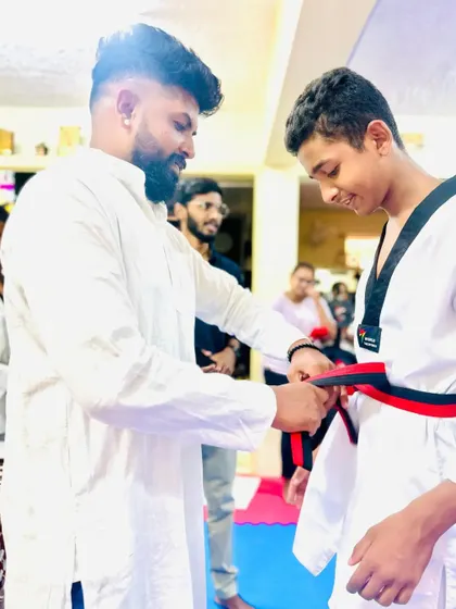 A proud moment for this senior student receiving his red and black belt.
