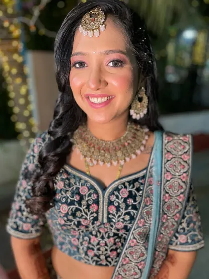 A beautiful reception look. The bride is glowing in a dark green and blue embroidered lehenga with soft pink eye makeup.