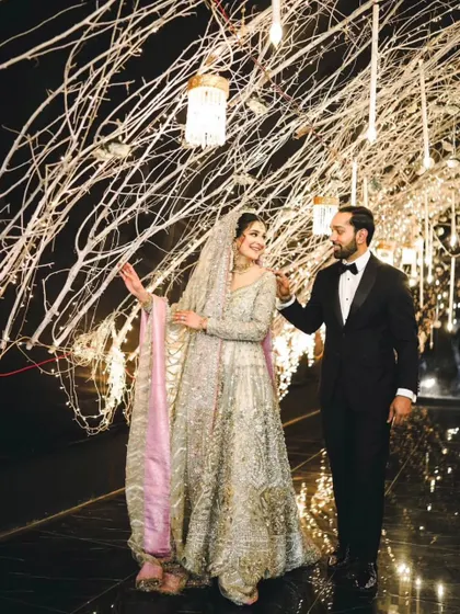 A candid shot of the couple walking through their beautifully decorated reception venue. Their interaction feels natural and full of love.