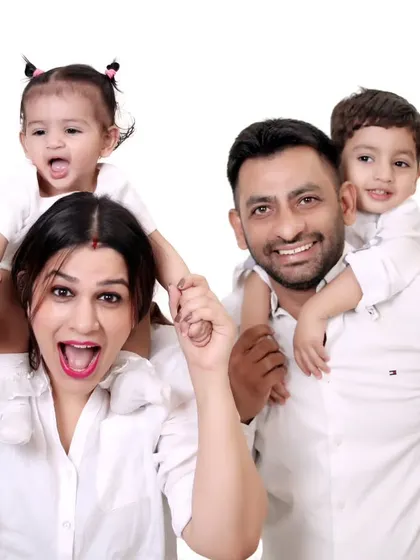 A fun and energetic family photo with children on their parents' shoulders.