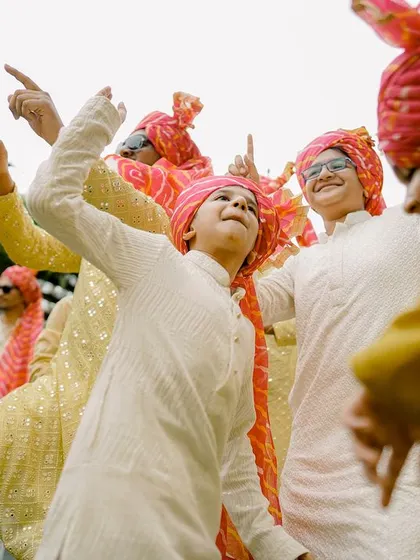 The groomsmen dancing with energy, their matching turbans adding a pop of color to the celebration.