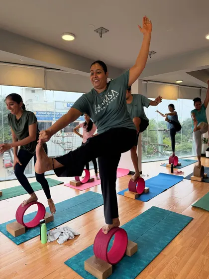 The joy of accomplishment! A student smiles as she masters a balancing pose on the yoga wheel.