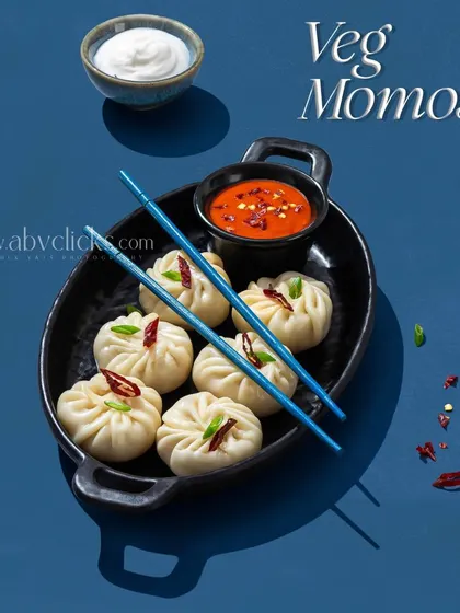 A platter of perfectly shaped momos served with a spicy dipping sauce and mayonnaise.