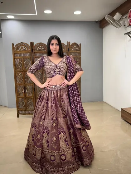 A confident pose in this beautiful purple lehenga, showcasing its intricate weaving and patterns.