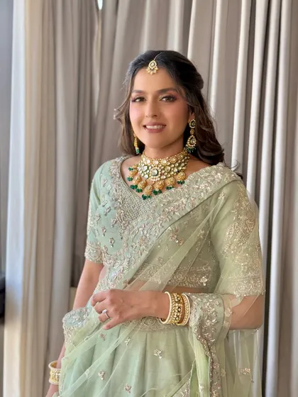 A full-length shot of the client, showing how the light green outfit is complemented by the soft makeup.