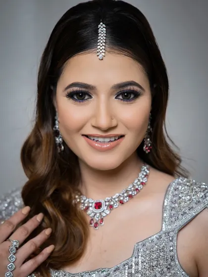 A happy and confident look for an evening celebration. This model wears a silver lehenga, beautifully accessorized with a ruby and zircon necklace and a delicate maang tikka.