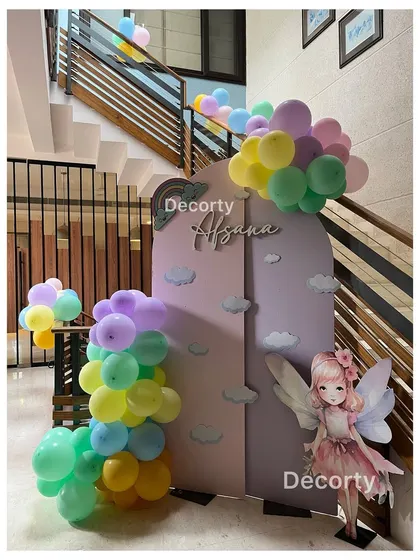 A whimsical fairy and rainbow-themed decor piece placed by a staircase, showing how I utilize all areas of the event space.