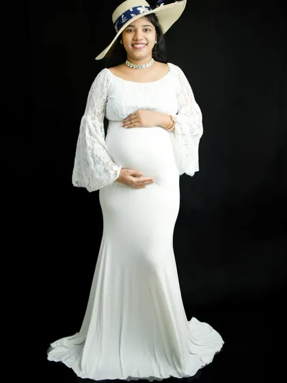 We can add simple props to personalize your solo session. Here, we added a stylish straw hat to complement the white lace gown, creating a chic and sophisticated maternity look.