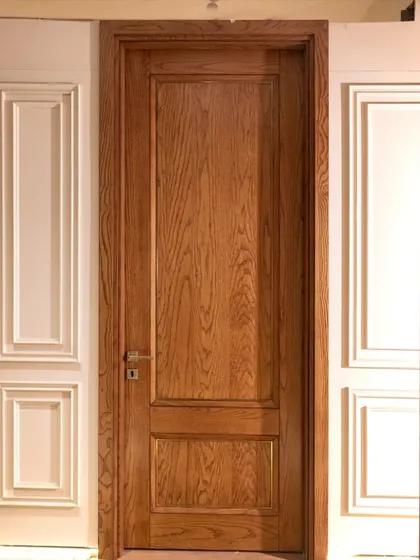 This crown-cut ashwood veneer door features a subtle metal inlay and a two-panel design, which helps to elongate the appearance of a 9-foot doorway.