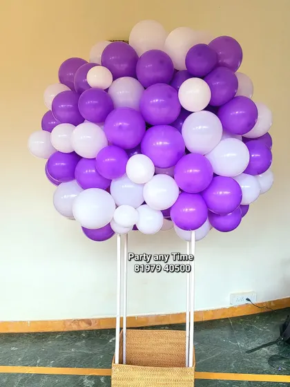 A hot air balloon prop made of purple and white balloons, ideal for a creative baby photoshoot.