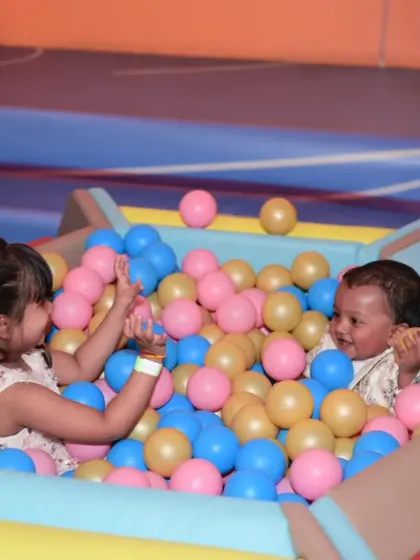 Two little ones sharing a moment in the ball pit. Our play zone is a great place for children to interact and make new friends.
