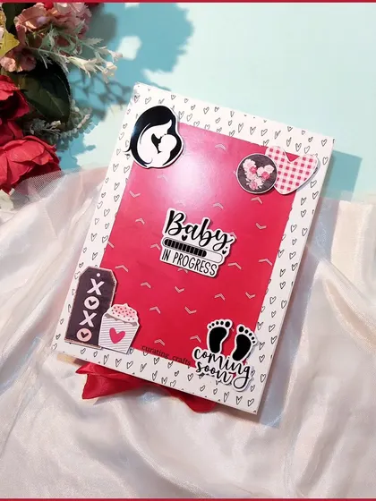 The cover of this maternity photo album says "Baby in progress" and "coming soon." It's a cute and exciting way to start a memory book for the little one on the way.