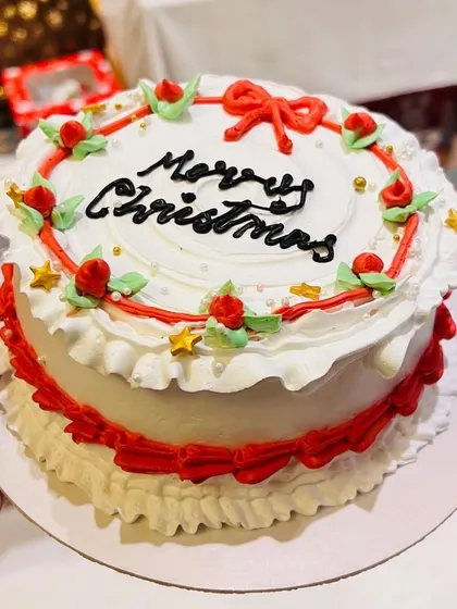 A festive Merry Christmas cake with classic red and green decorations.