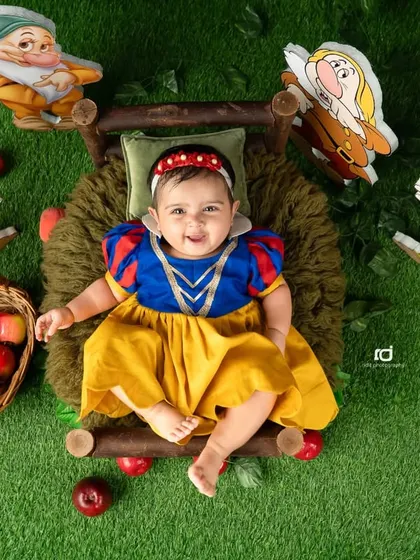 A happy Snow White surrounded by her seven dwarf friends. The bright colors and cheerful expression make this photo so lively.