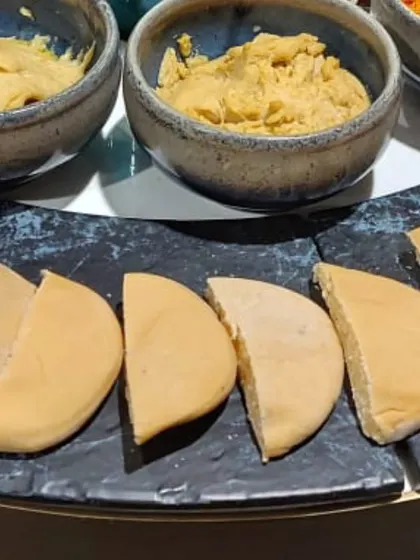 A close-up of the hummus and pita bread from the ALSORG corporate event. I offer a variety of flavors, including classic and peri-peri, to cater to different tastes.
