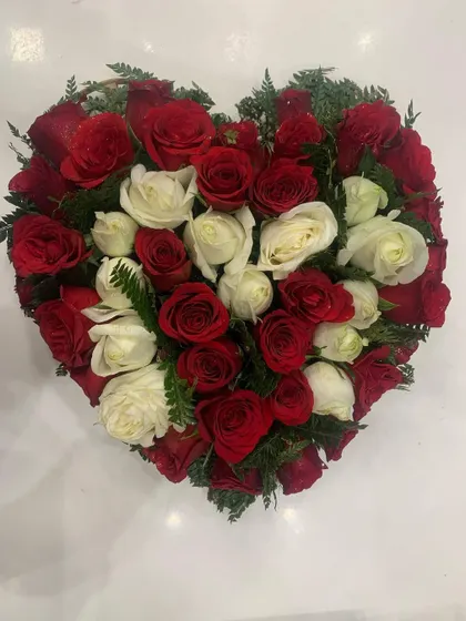 Another look at the red and white rose heart arrangement, showing the careful placement of each flower to create the perfect shape.