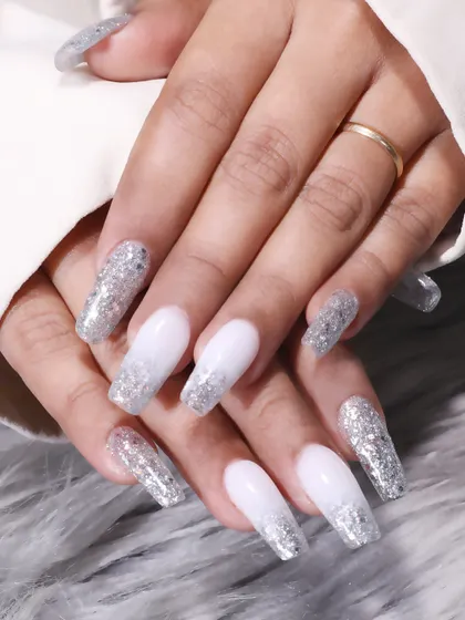 The full set of the white and silver glitter nails, showcasing the long, elegant coffin shape and the seamless gradient effect.