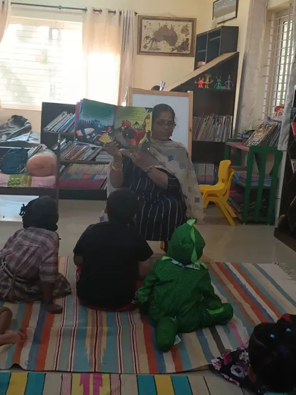 Another shot of the storyteller reading, with a child in a costume adding to the fun.