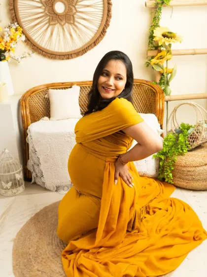 A playful and happy kneeling pose. The yellow gown brings a sense of sunshine and joy to this maternity portrait.