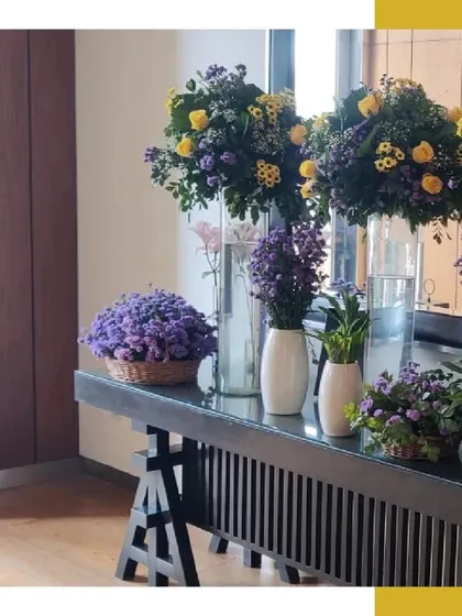 A beautiful floral arrangement of purple and yellow flowers, reflecting in a large mirror, adding depth and color to the reception space.