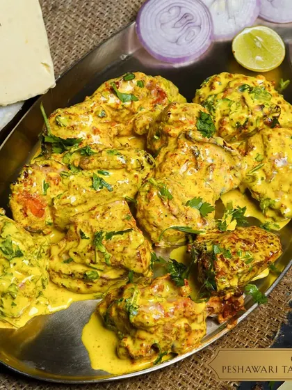 A full platter of my Chicken Peshawari Tandoori. The tandoor-cooked chicken is covered in a vibrant, creamy yellow sauce and garnished with fresh cilantro. It’s a dish that balances the smokiness of the tandoor with the rich, aromatic spices of Peshawari cuisine.