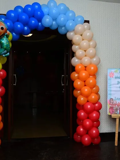 The entrance to a Cocomelon party, featuring a colorful balloon arch with a character foil balloon. This creates an exciting first impression for the young guests.