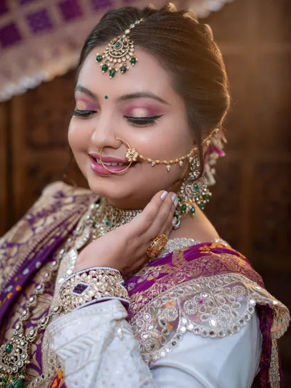 The soft lighting enhances the glow of her skin and the richness of her traditional outfit.