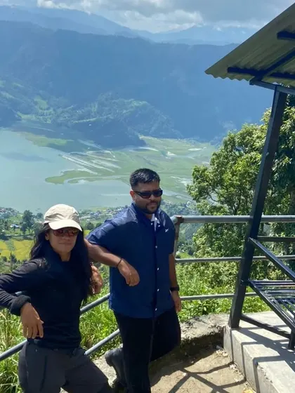 A moment of rest and camaraderie with fellow travelers on the trails of Nepal, overlooking a serene lake.