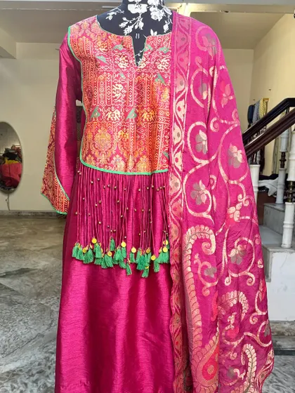 The full view of the magenta suit set with its beautiful banarasi dupatta.