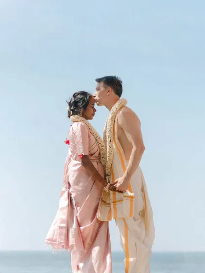 A husband's gentle kiss on his wife's forehead. This tender portrait of Bhavana and Michael, dressed in traditional South Indian wedding attire against the open sky, is a symbol of love and respect.