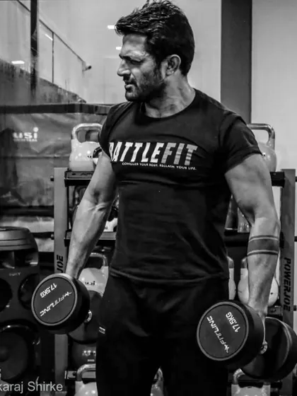 Holding 17.5kg dumbbells, focusing on building strength. As a coach, I believe in walking the talk and putting in the work myself.