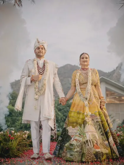 The couple's stunning entry through a cloud of smoke, holding hands as they begin their new journey together. The bride's unique lehenga tells a story in itself.