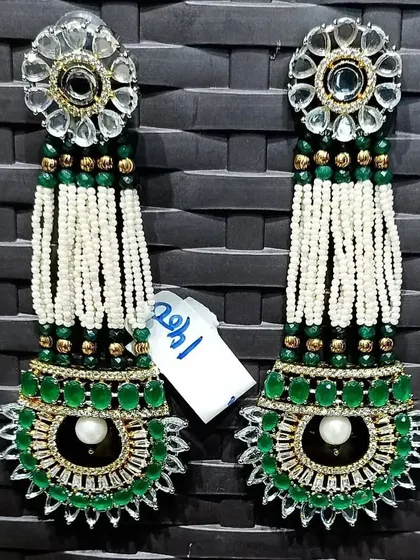 A unique pair of long, hanging earrings with Kundan tops and layered pearl and green bead tassels. These are very stylish and have a beautiful movement.