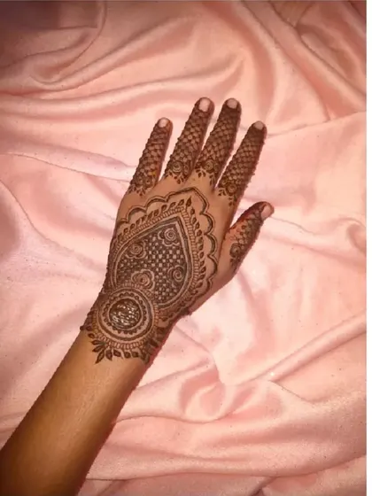 A lovely heart-shaped mandala design on the palm, filled with intricate net-like details. A very popular choice for festive occasions.