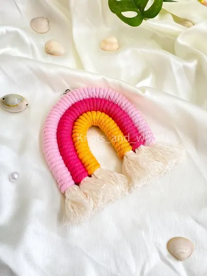 A close-up of a vibrant rainbow keychain in shades of pink, fuchsia, and yellow. These mini rainbows are an ideal choice for return gifts for birthday parties or baby showers. They are small, cute, and handmade with love.