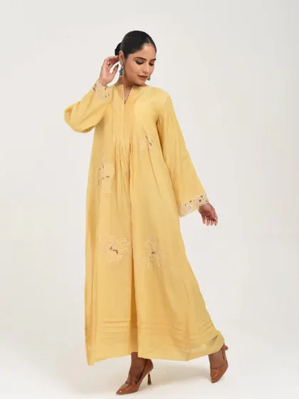 A beautiful pastel yellow dress with lace-insert details and a relaxed, flowing silhouette.