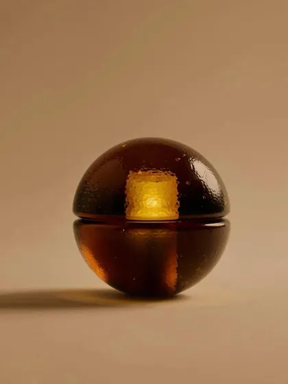 A close-up of the Bocci 14p in a rich sepia color, showcasing its warm, candle-like glow.