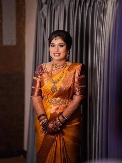 A full portrait showing the beautiful mustard yellow saree and the classic updo.